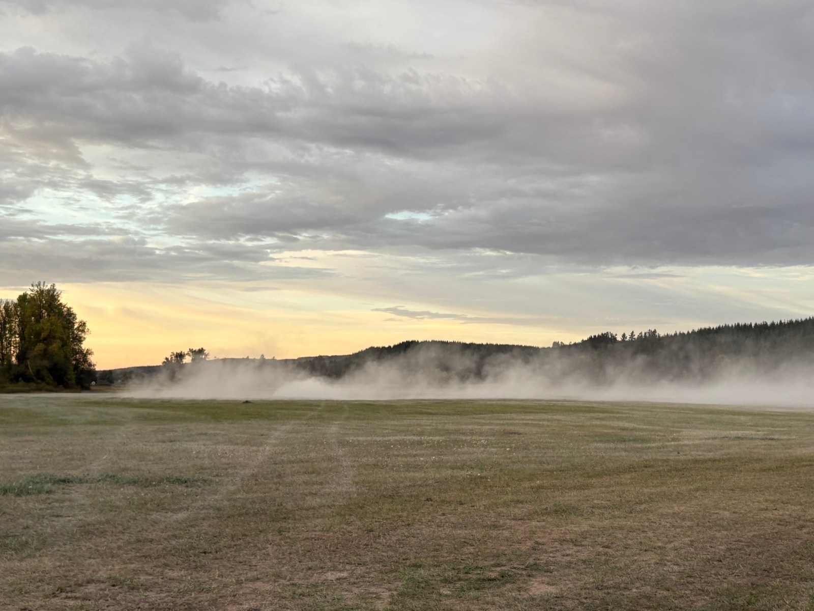 Rock dust spread across a misty field at sunrise